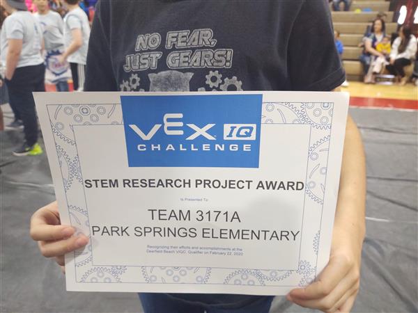 student holding a STEM award certificate
